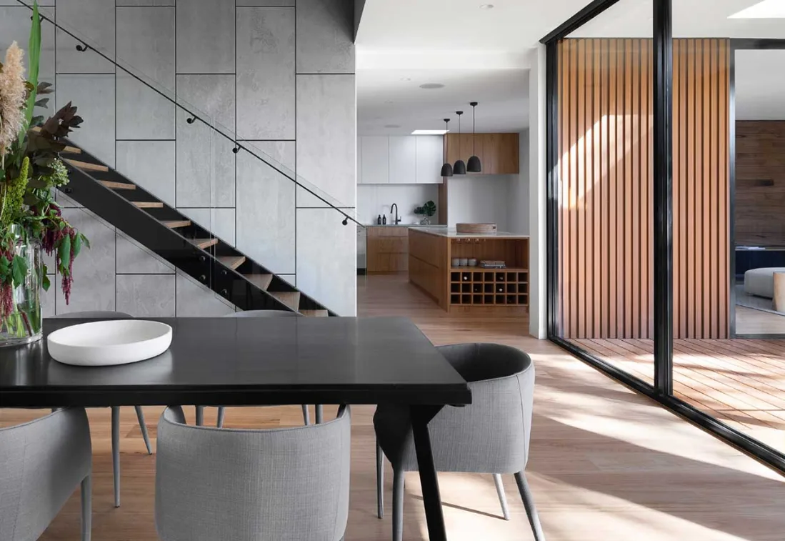 Interno moderno con zona pranzo, scala e finiture curate