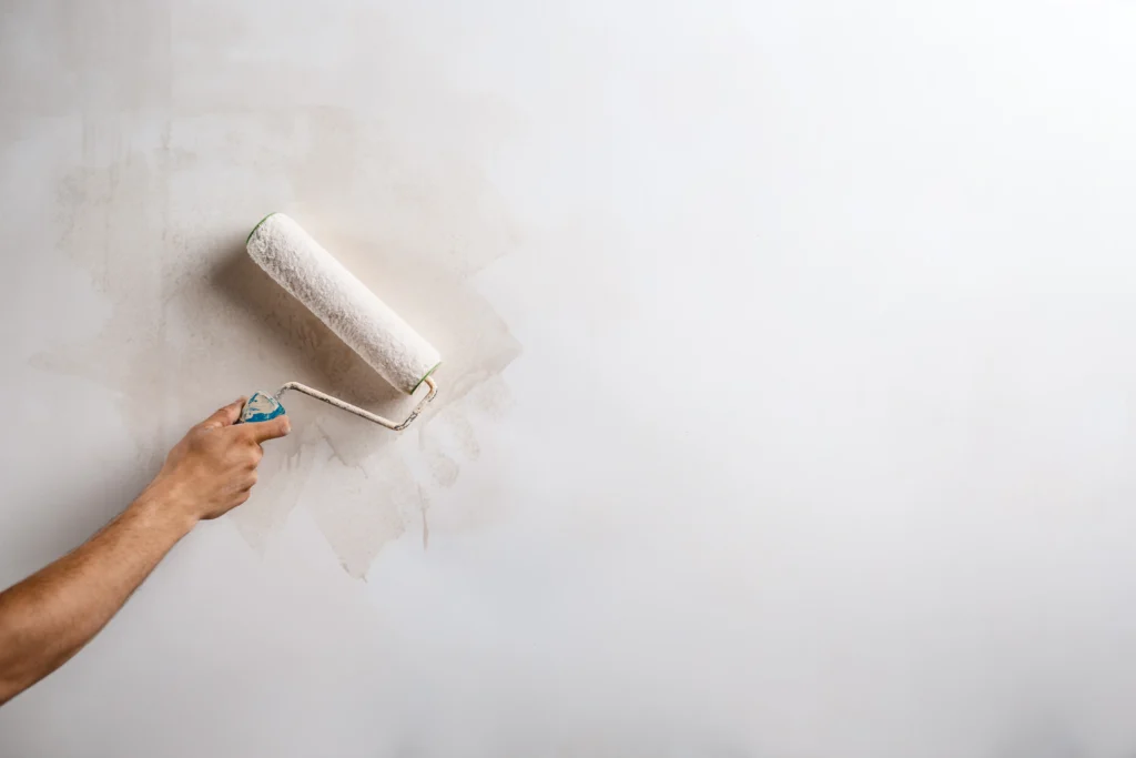 Applicazione di pittura su parete interna durante una tinteggiatura