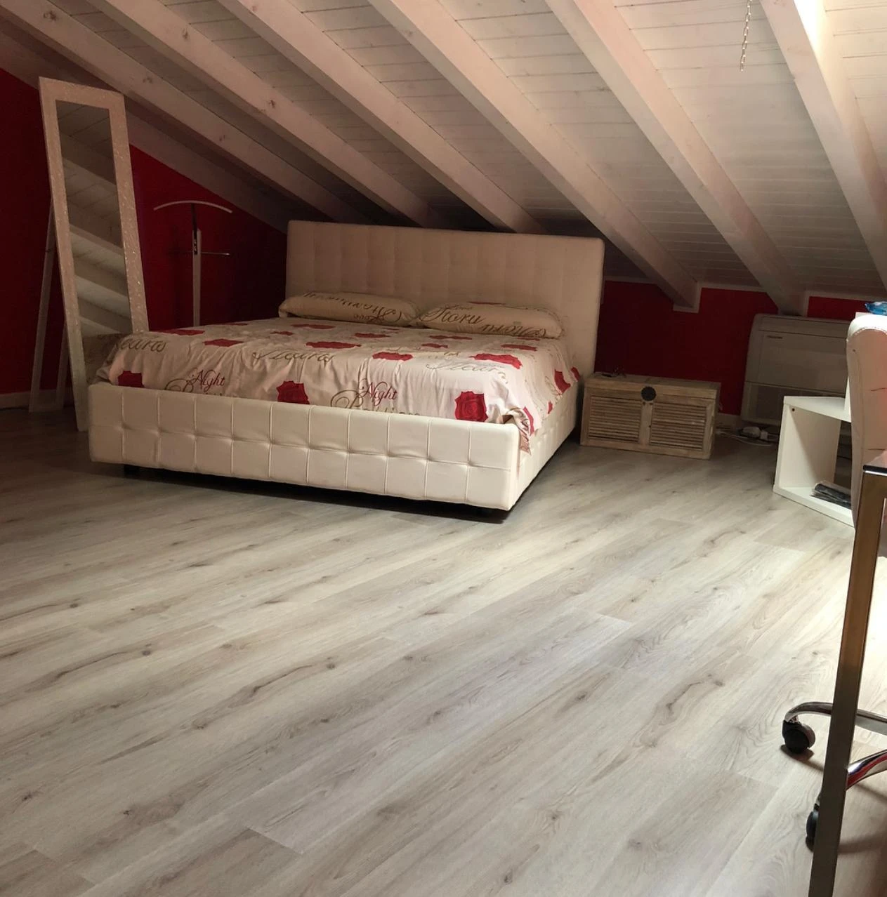 Ambiente con pavimento in laminato e travi in legno sbiancate a soffitto